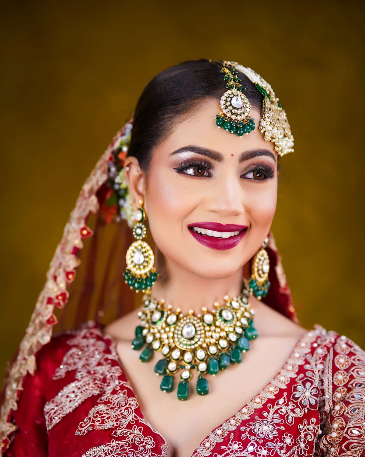 Candid photograph of a bride laughing, bridal makeup and hair styling visible